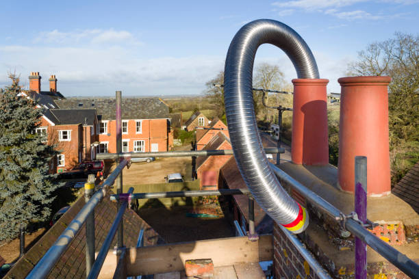 Installing a flexible steel flue liner into a chimney during a wood burning stove installation, UK